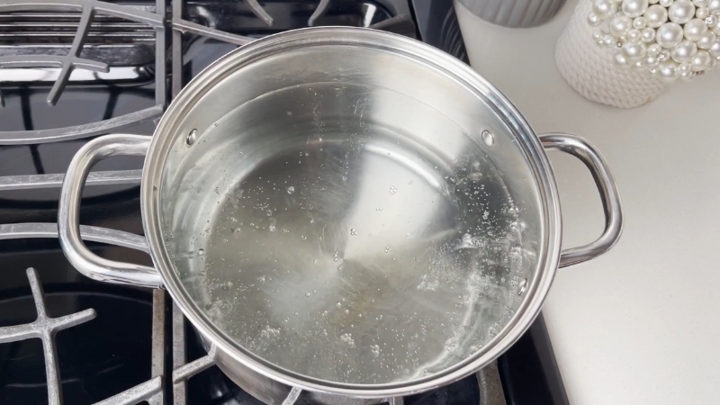 A Pot of Water Heating up On a Stove, Ready for Boiling