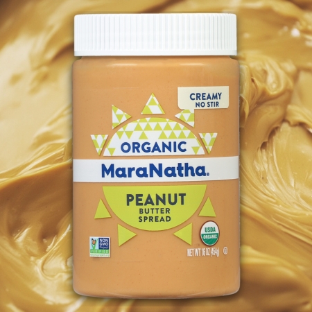 Jar of MaraNatha Organic Creamy No-Stir Peanut Butter against a peanut butter background