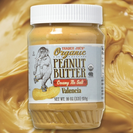 Jar of Trader Joe’s Organic Creamy No Salt Valencia Peanut Butter on a peanut butter background