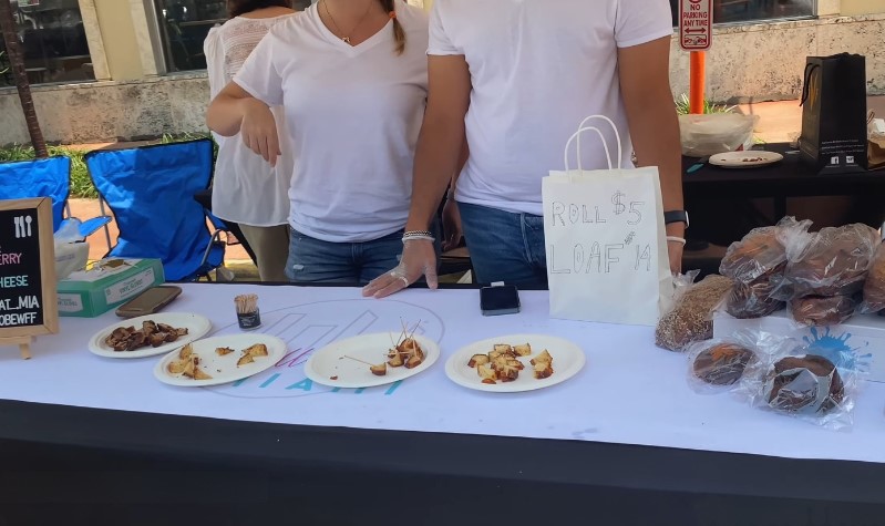 Freshly baked loaves and samples displayed at an outdoor market