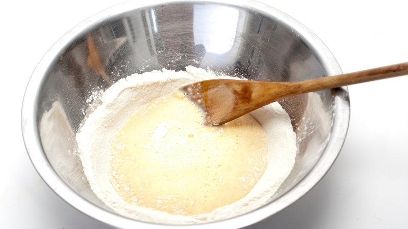 Raw pancake batter in a mixing bowl with flour and eggs