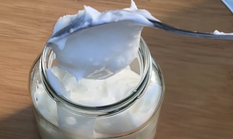 Creamy mayonnaise scooped from a glass jar