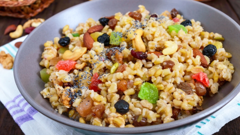 A bowl of grains mixed with nuts and dried fruits