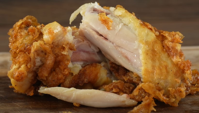 A close-up view reveals the tender, juicy interior of freshly fried chicken