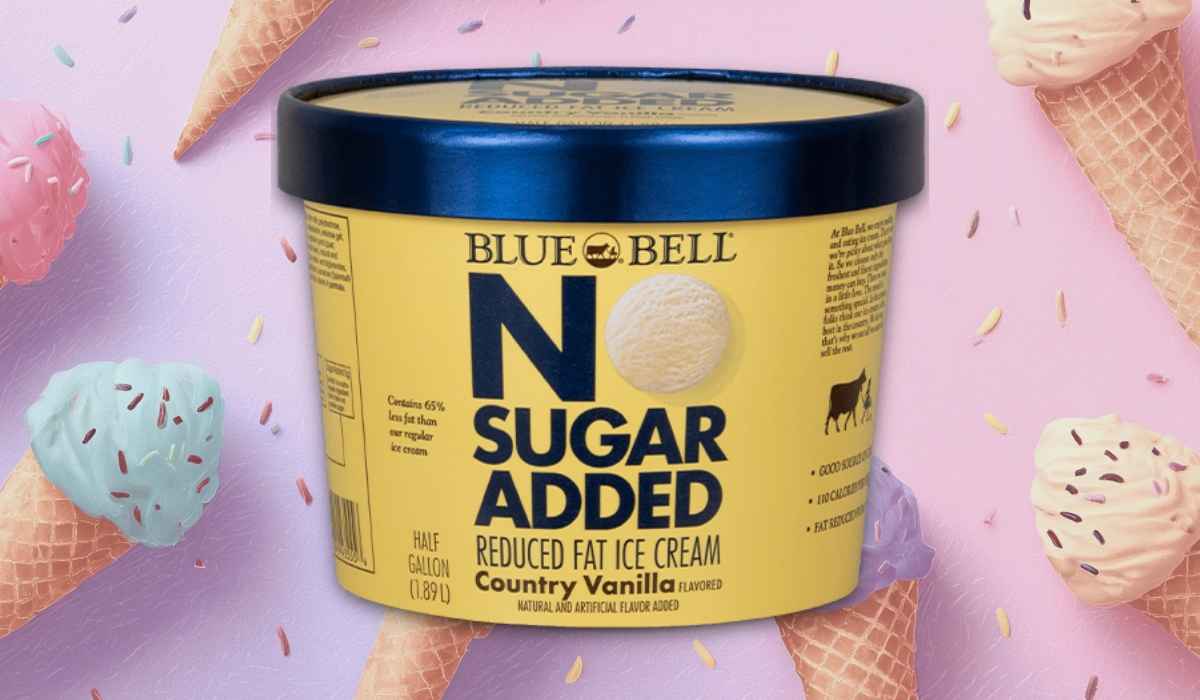 Blue Bell No Sugar Added Country Vanilla reduced fat ice cream half-gallon container with yellow and navy packaging on a pastel ice cream cone background
