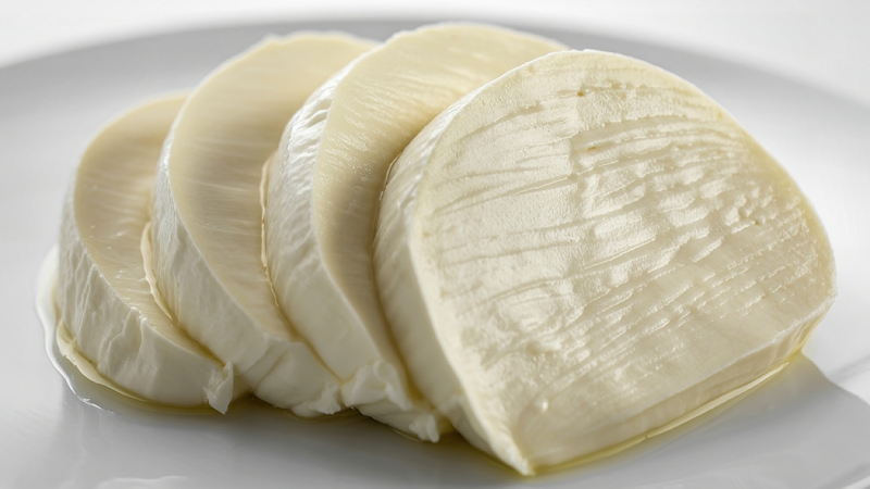 Fresh mozzarella slices rest on a plate, sealed storage keeps moisture and freshness