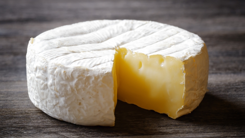A cut wheel of Brie shows why soft ripened cheese needs breathable wrapping to stay fresh