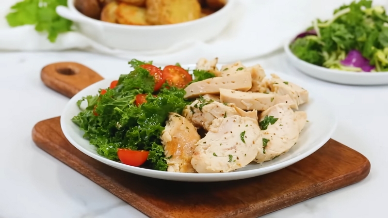 Plate of sliced leftover chicken with greens and tomatoes ready to be reheated
