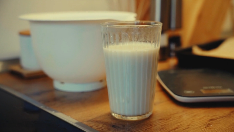 Glass of sour milk on a kitchen counter showing early signs of natural fermentation