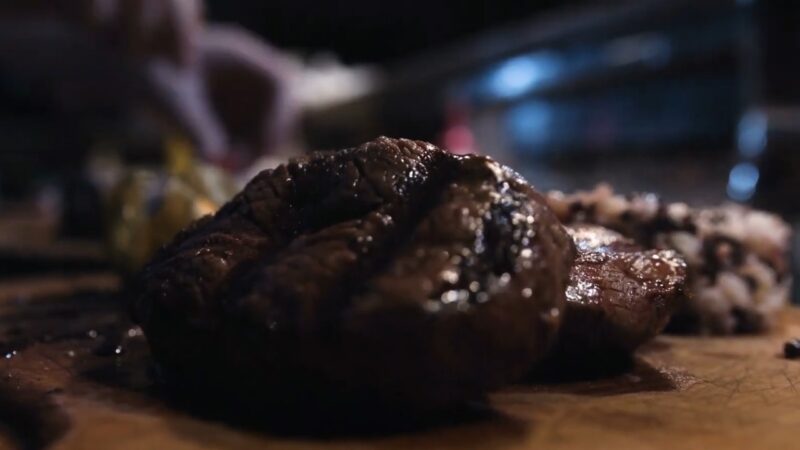 Cooked steak on a cutting board with juices on the surface